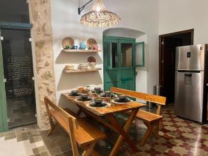 Un comedor con una mesa y un refrigerador. en Casa Galeria Campeche, en Campeche