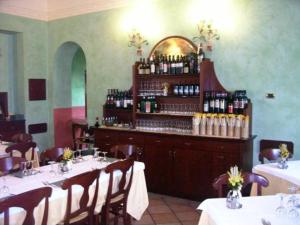a restaurant with tables and a bar with wine bottles at Albergo Escondido in Soresina
