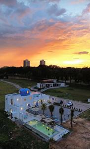 un grand bâtiment blanc avec un coucher de soleil en arrière-plan dans l'établissement The Oiia Lakeview A'Famosa, Resort Melaka, à Simpang Empat