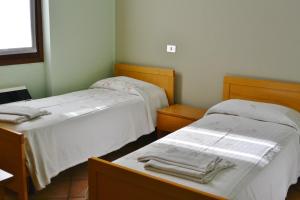 Habitación con 2 camas, sábanas blancas y toallas. en Albergo Escondido, en Soresina