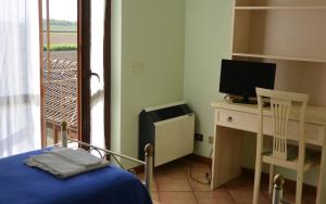 a bedroom with a bed and a desk with a computer at Albergo Escondido in Soresina