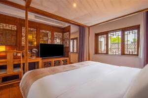 A television and/or entertainment centre at Nanxun Boyang New Century Mingting Resort Hotel