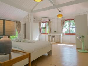 a bedroom with a bed and a table and windows at Beachfront Wooden House 3Br & Sunset Views in Taling Ngam Beach