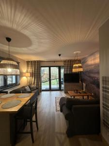 a living room with two couches and a table at Apartament Bujać w Obłokach Karpatia - 5D Apartamenty in Karpacz +21 photos