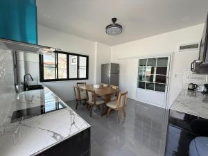 a kitchen with a table and chairs in it at The Wing Pool Villa Surin in Surin