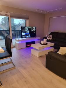 a living room with a couch and a flat screen tv at Ferie leiligheten ved stranden in Kristiansand +12 photos