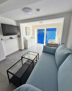 a living room with a blue couch and a television at Vacation Home Rovanjska in Rovanjska