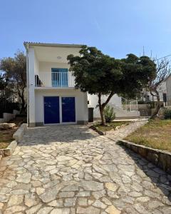 a house with a stone driveway in front of it at Vacation Home Rovanjska in Rovanjska
