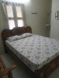 Suganya Lodge في Virudunagar: سرير جالس في غرفة مع نافذة