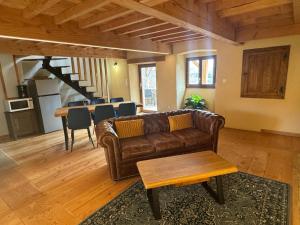 a living room with a brown couch and a table at La Petite Toscane d'Auvergne in Isserteaux