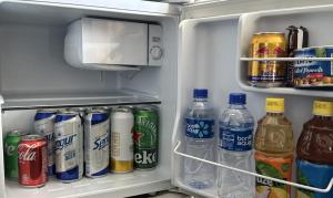 an open refrigerator filled with bottles of soda and drinks at City Tower Hotel in Ulaanbaatar