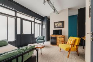 a bedroom with a bed and two chairs and a dresser at La Fabrique à Souvenirs in Saint Malo