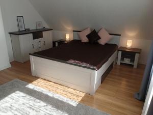 una camera da letto con un letto grande con due comodini di Ferienhaus mit Schwimmteich in idyllischer Lage a Jeleniewo