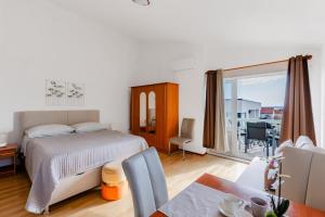 a bedroom with a bed and a dining room at Apartments Papic in Vrsi