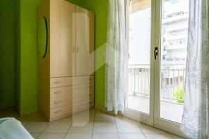 a bedroom with a dresser and a large window at Homiday - Via Gramsci Giallo in Pineto