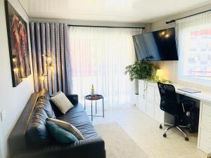 a living room with a couch and a desk at Large Terrace Jardin Apartment in Puerto de Santiago