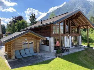 domek z krzesłami przed nim w obiekcie IM WEIDACH Superior Chalets w mieście Leutasch