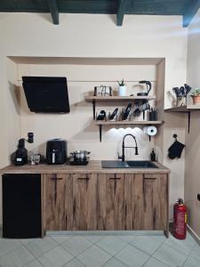 a kitchen with a sink and a tv on the wall at Marily's seaview suite with private JACUZZI and BBQ in Spartià +23 photos