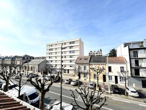 a city street with cars parked in front of buildings at 2 Carteret studio cosy proche centre ville in Reims