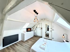 a attic bedroom with a bed and a fireplace at 2 Carteret studio cosy proche centre ville in Reims