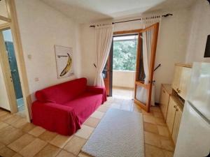 a living room with a red couch and a window at Cacciatore in Rosolina