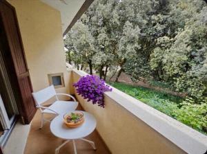 a balcony with a table and a window with purple flowers at Cacciatore in Rosolina