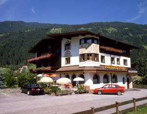 a large building with cars parked in a parking lot at Hotel Garni Maximilian in Zell am Ziller