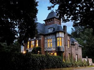 a large house with a tower on top of it at Le Manoir des Etangs in Etbos +38 photos