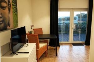a living room with a desk and a table and a window at Studio mit 1 Schlafzimmer in Oyten