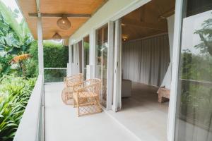 una casa con un patio al aire libre con sillas y mesas. en Hot Stone Club Ubud, en Ubud