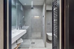 Un baño con ducha, lavabo e inodoro. en Aparthotel Adagio Stuttgart NeckarPark, en Stuttgart 30 fotos más