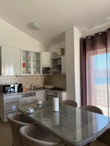 a kitchen with a table and some chairs and a kitchen at Holiday Home Panorama in Zubovići