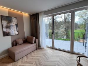 a living room with a couch and a sliding glass door at Hotel Pflugsmühle in Abenberg