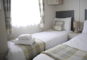 twee bedden in een kleine kamer met handdoeken erop bij 97 DANBURY in Redcar +27 foto's