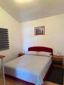 a bedroom with a bed with a red headboard at Holiday Home Panorama in Zubovići