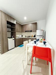 a kitchen with a white table and a red chair at The Square One City Mall Premium Family 3R2B 8pax by Luvit Stay in Subang Jaya