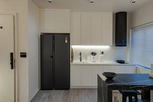 a kitchen with a black refrigerator and a table at Do Studioishome Homestay Dukkha 03 in Ha Long