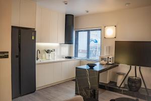 a kitchen with white cabinets and a black refrigerator at Do Studioishome Homestay Dukkha 03 in Ha Long