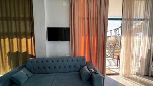a living room with a blue couch and a window at Datuna in K'obulet'i