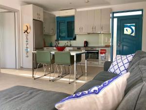 ein Wohnzimmer mit Sofa und eine Küche in der Unterkunft Villa Mandarini in Kamilari