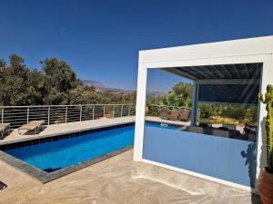 Blick auf einen Swimmingpool von einem Haus aus in der Unterkunft Villa Mandarini in Kamilari