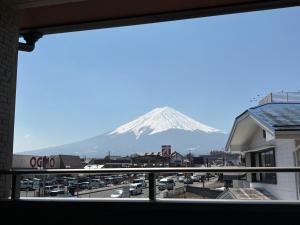 a view of a snow covered mountain from a window at Hostel labeek in Fujikawaguchiko