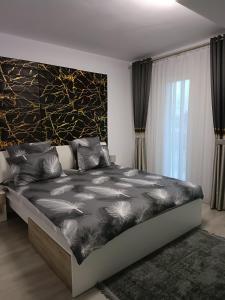 ein Schlafzimmer mit einem Bett mit einer schwarz-weißen Bettdecke in der Unterkunft GH apartments in Gura Humorului
