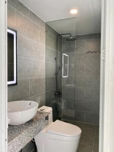 a bathroom with a toilet and a sink and a shower at Maison Mia Hotel & Apartment in Ga Tân Thiết +29 photos