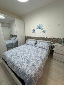 1 dormitorio con 1 cama con flores azules en la pared en Loft con spazio esterno Lissa, en Riomaggiore
