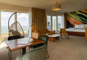a hotel room with a bed and a table and chairs at THE GRAND Ahrenshoop in Ahrenshoop +153 photos