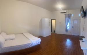 a bedroom with a bed and a wooden floor at KS Guest House in Cilacap +4 photos