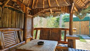 a room with a wooden table in a hut at Natural Haven with Netflix Kubo Videoke & Alfresco Dining in Dasmariñas