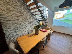 a dining room with a wooden table and a brick wall at Paredes 10 in Alenquer