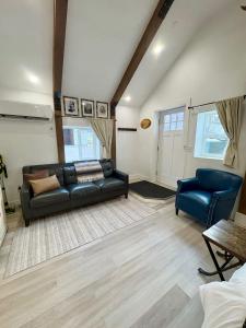 a living room with a black couch and a blue chair at Watershed- IN TOWN walk to everything in Lava Hot Springs